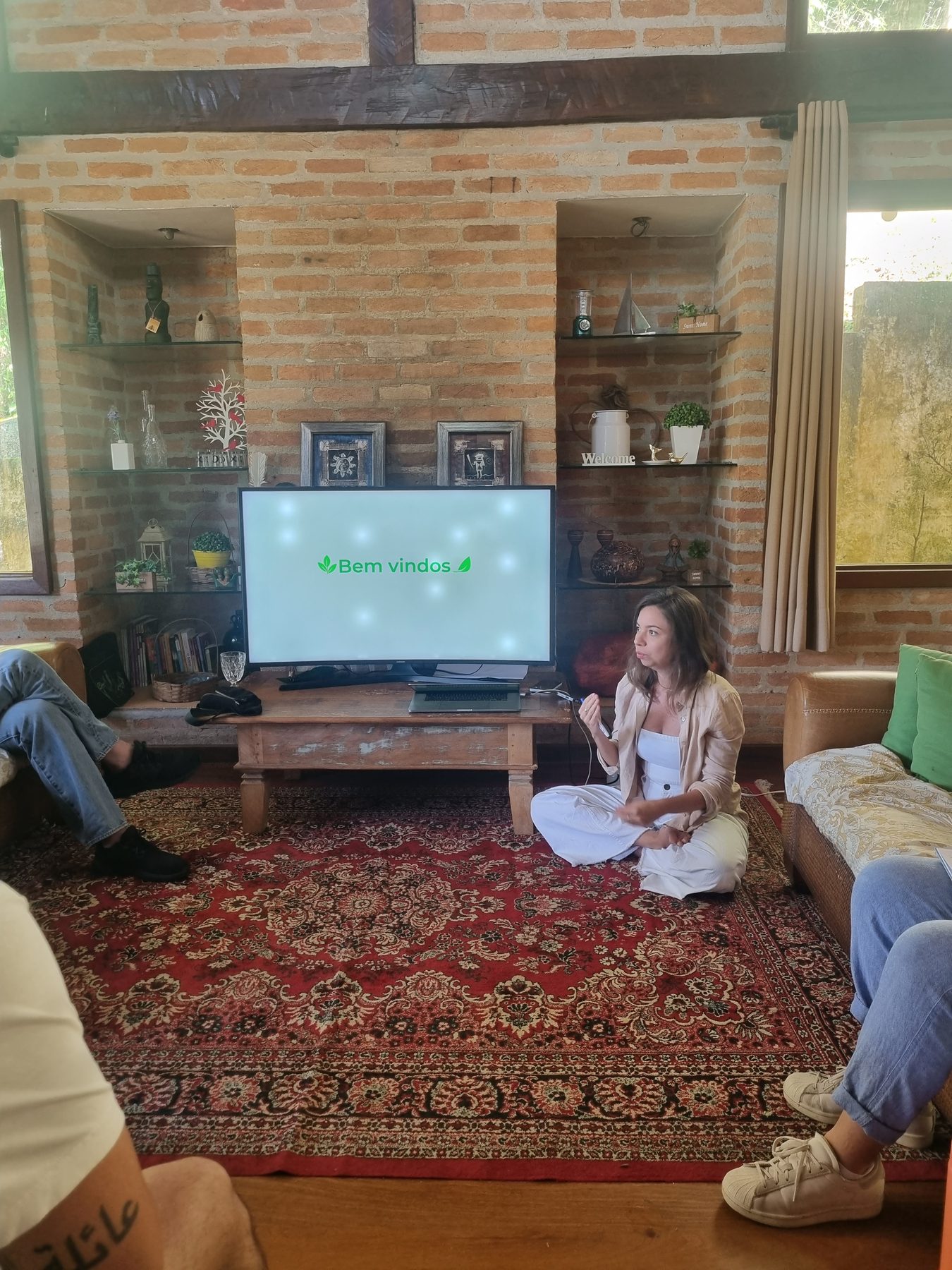 Participantes reunidos em uma sala enquanto uma pessoa conduz uma conversa